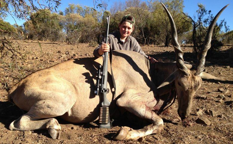 Boy posing with his trophy eland bull from a game hunting safari