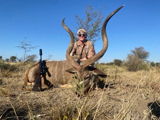 man posing with kudu bull he shot.
