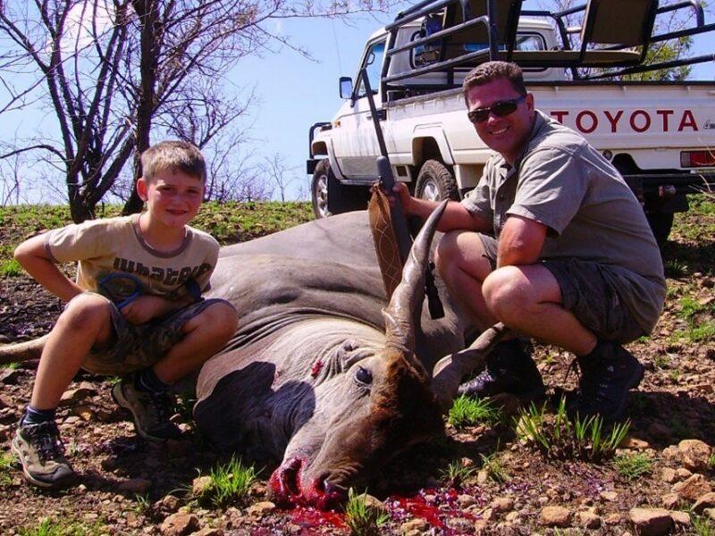 Man and son posting with an eland bull shot in the veld.