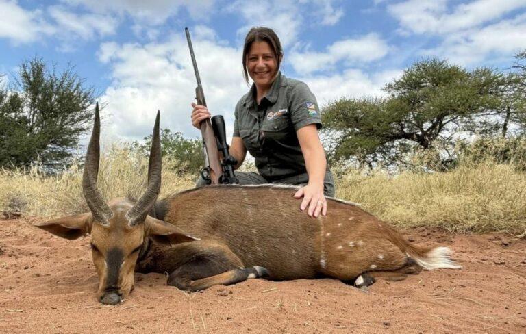Lady hunter posing with her gun and a Limpopo bushbuck