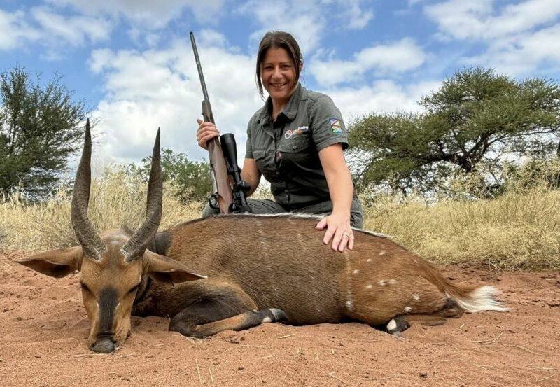 Lady hunter posing with her gun and a Limpopo bushbuck