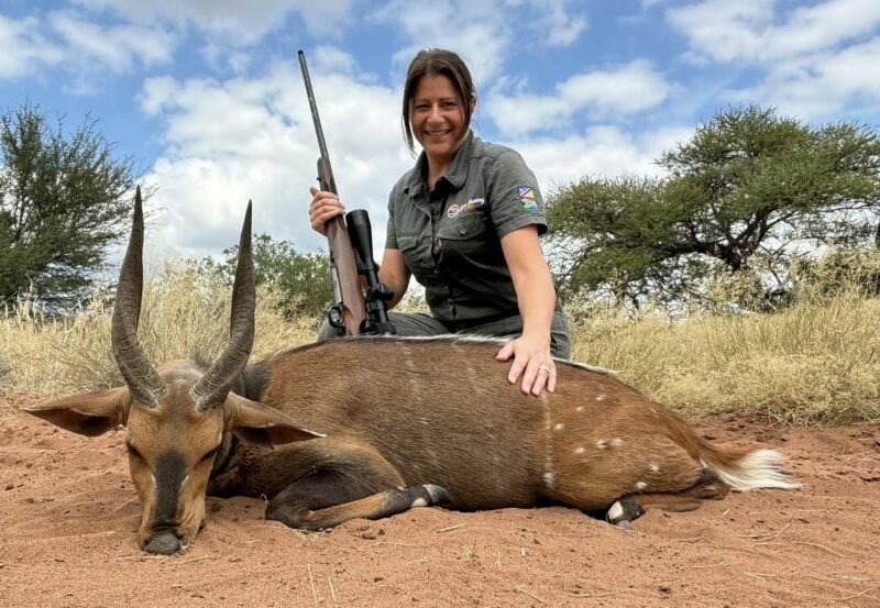 Lady hunter posing with her gun and a Limpopo bushbuck
